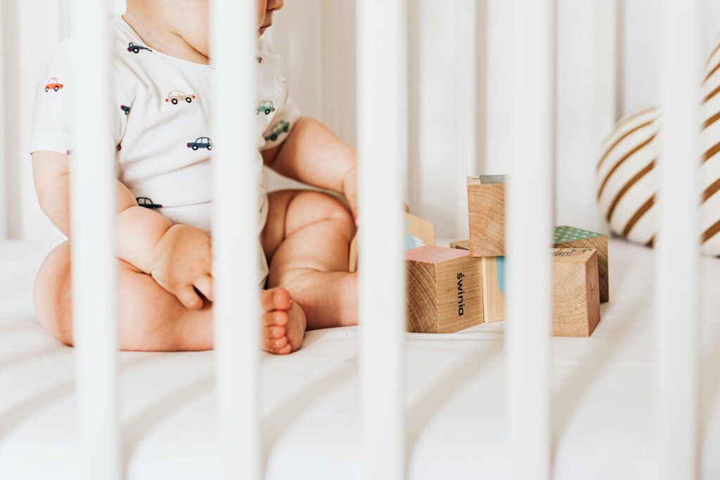 Baby sitting and playing in a non-toxic bassinet