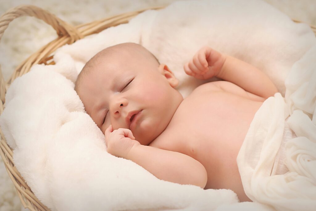 Baby sleeping on white cotton non-toxic bassinet