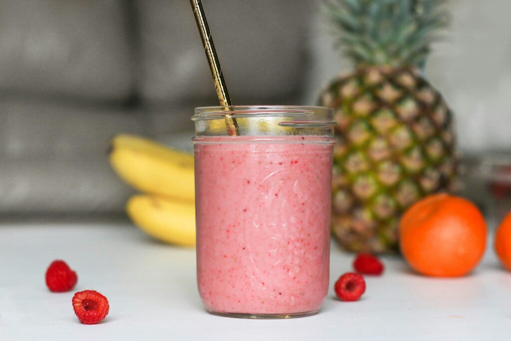 non-toxic protein shake in a mason jar with a metal straw and fruit