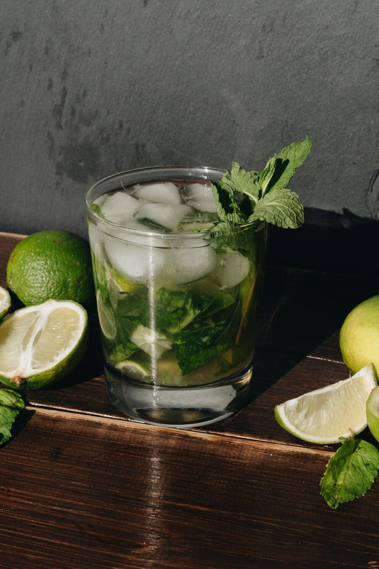 A refreshing mojito mocktail with lime and mint on a rustic wooden surface, perfect for st. patricks day