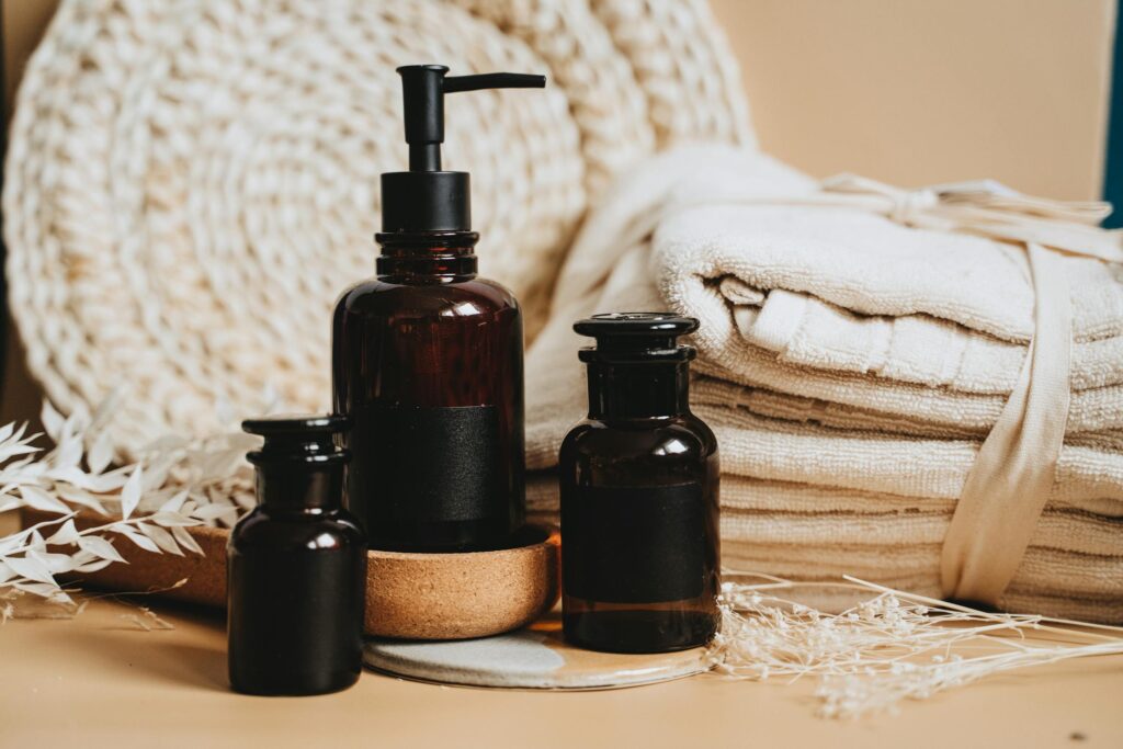 Elegant display of cleaning products featuring pump bottles, towels, and natural accents.