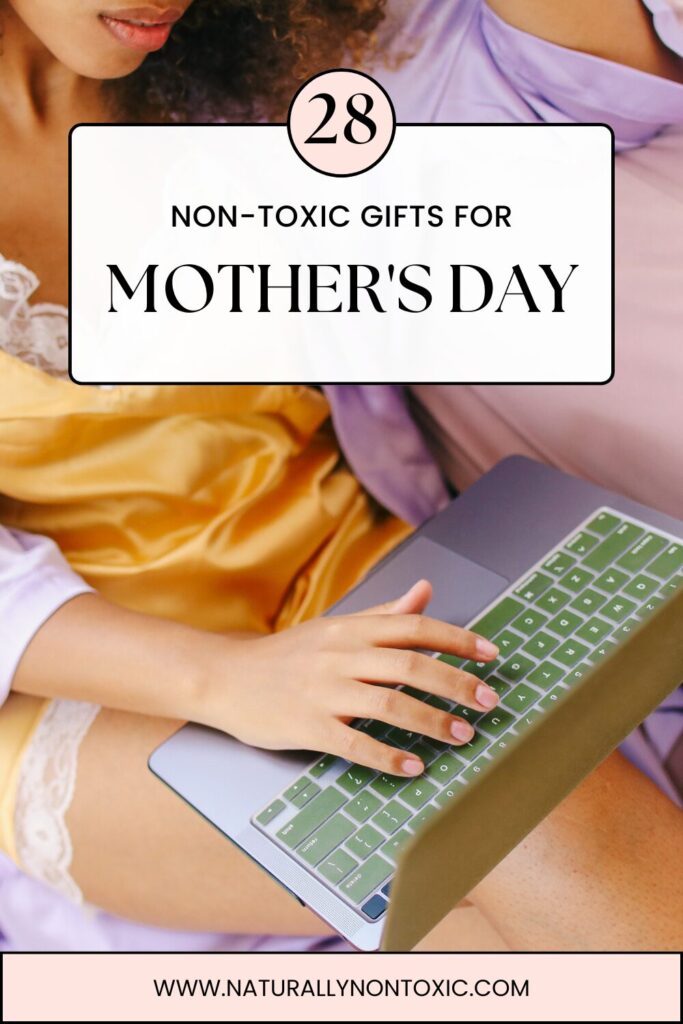 A woman in silk pajamas and a robe sits comfortably looking on her laptop with text that reads 28 Non-Toxic Gifts for Mother's Day
