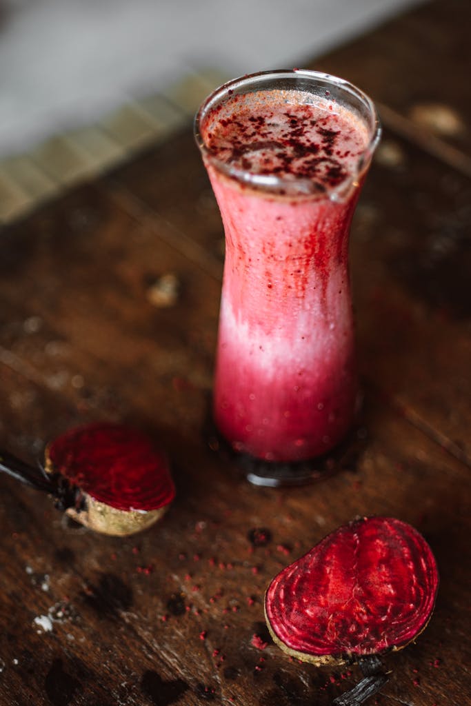 A vibrant beetroot smoothie served in a glass on a rustic wooden table, capturing fresh earthy flavors.