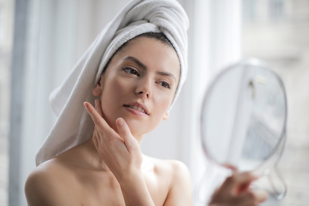 A serene and elegant woman enjoys a non-toxic skincare ritual, enhancing her natural beauty in the comfort of her home.