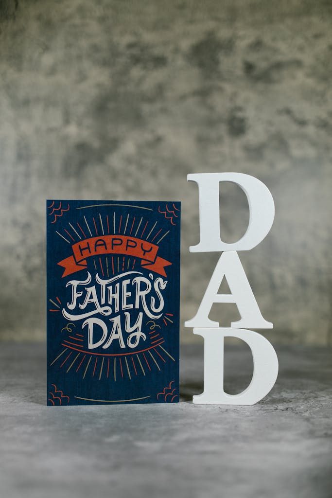 Close-up of a stylish Father's Day card with 'DAD' decorative letters on a textured background.