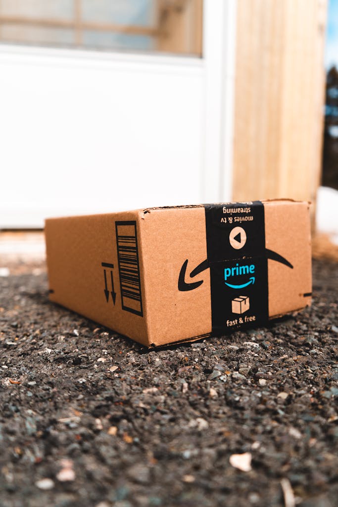 A cardboard box marked with Amazon Prime logo placed outside on a porch, ready for delivery.