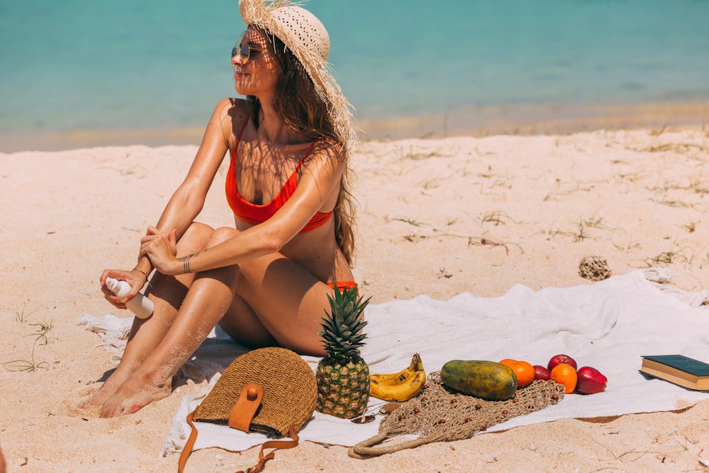 A woman sunbathing on a tropical beach surrounded by fruits, using sun protection lotion. Ideal non-toxic summer gear leisure scene.