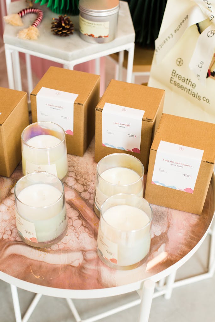 A high-angle shot of artisanal scented candles and packaging on a stylish table.