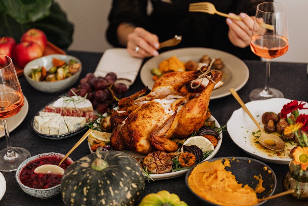A festive Thanksgiving dinner spread featuring a golden roasted turkey, vegetables, and wine, perfect for holiday dining.