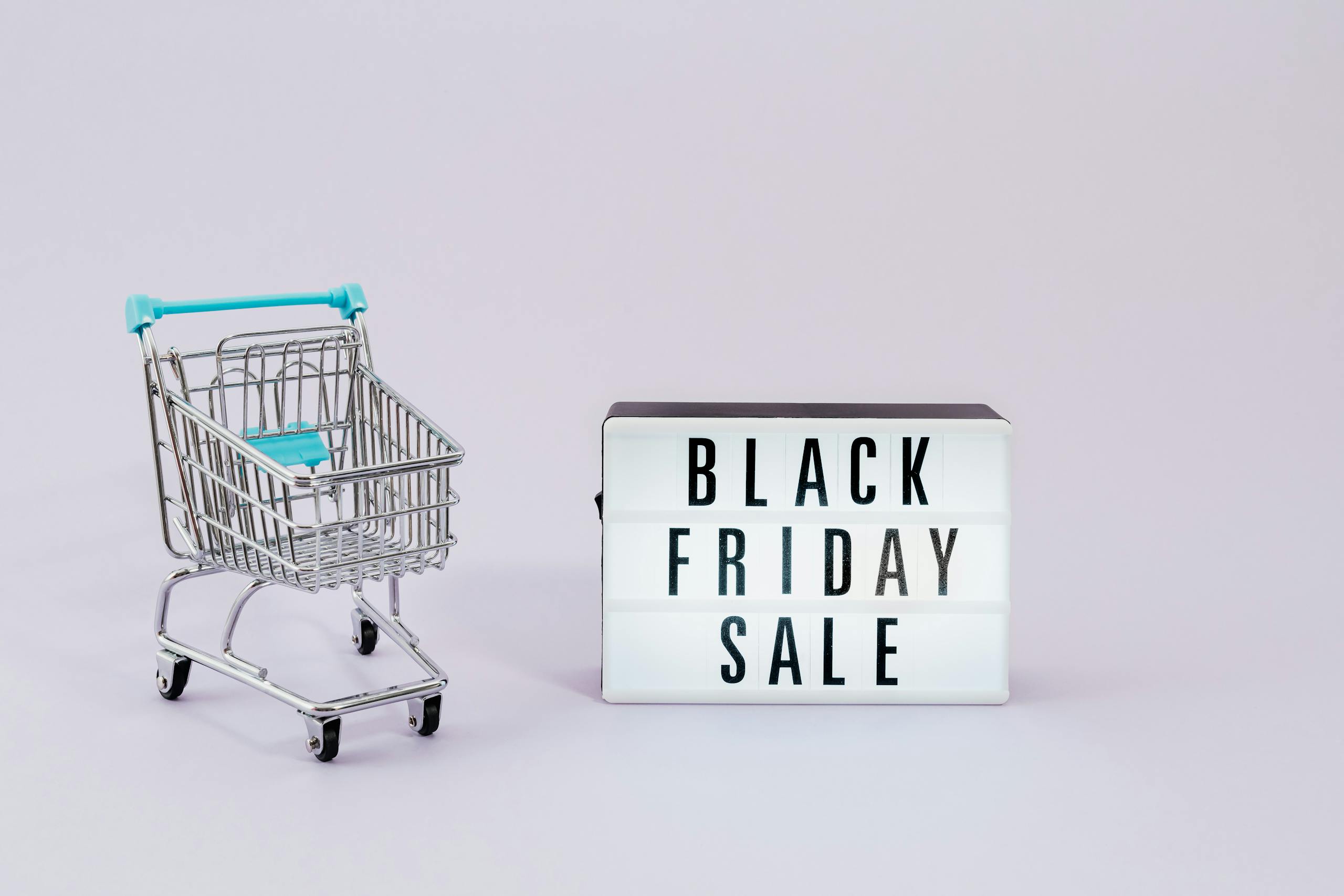 Minimalist image of shopping cart and Black Friday sale sign, perfect for promoting non-toxic Black Friday deals and Cyber Monday sales.