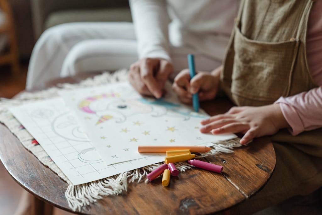 A cozy moment of bonding between a mother and child while coloring with non-toxic crayons indoors, perfect for non-toxic gift ideas.