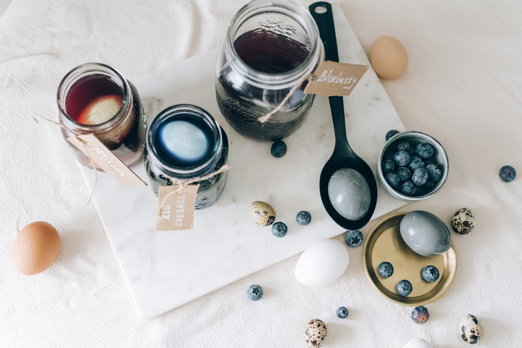 A top view of eggs being dyed naturally with blueberries and other ingredients.