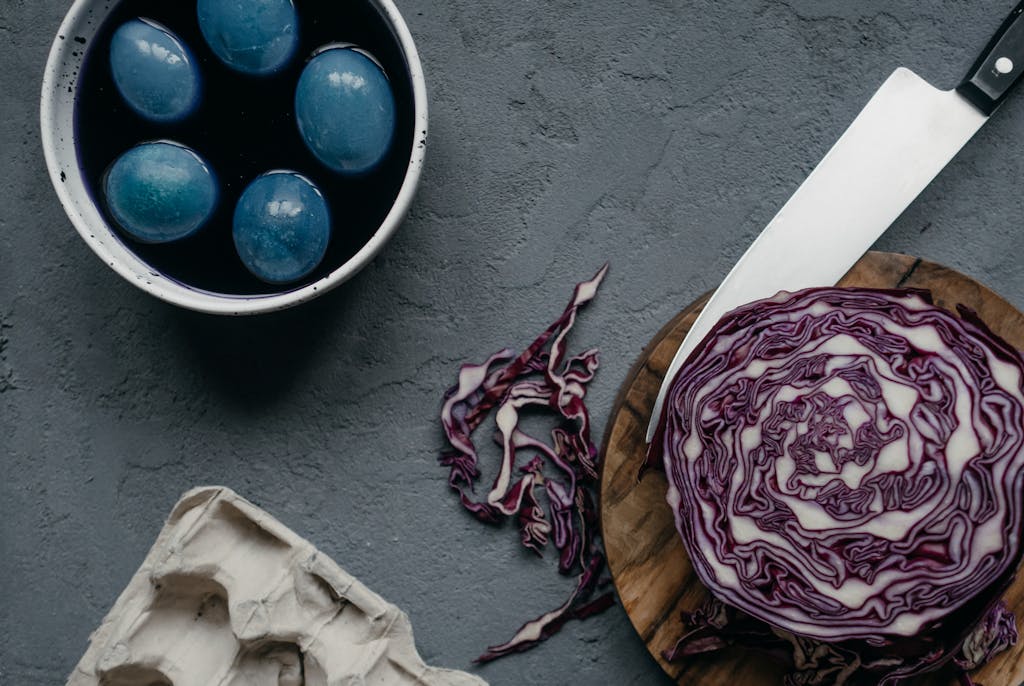 Flat lay of Easter eggs dyed with natural red cabbage on a stylish kitchen setup.