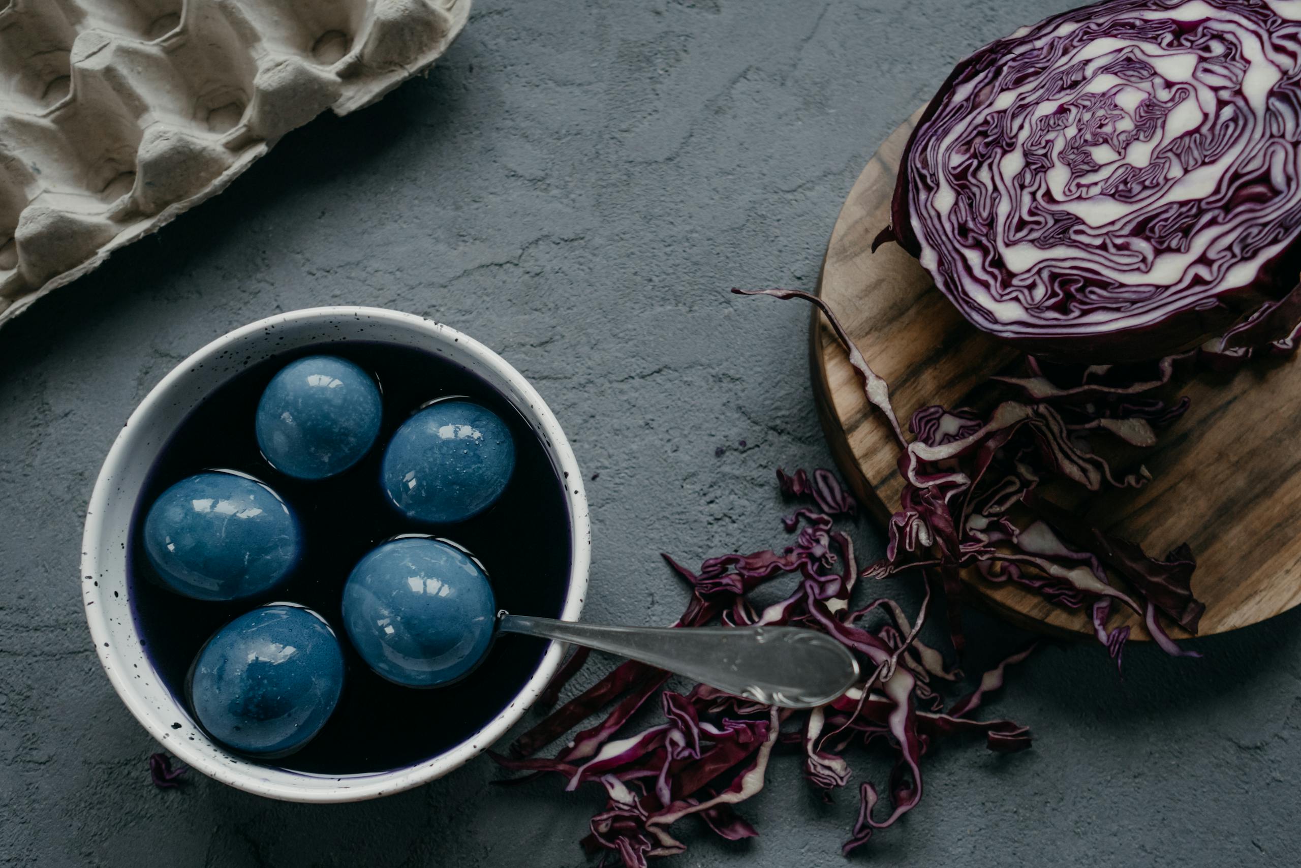 Naturally dyed blue Easter eggs using red cabbage in a rustic setting.