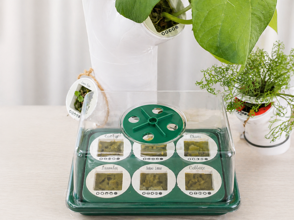 a 3D printed seedling nursery sits on top of an indoor smart garden, showing seedlings beginning to sprout.