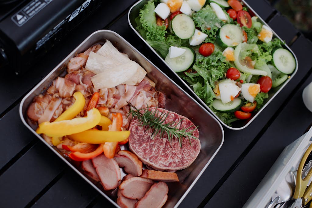 A delicious assortment of meats and fresh salad ingredients prepared for a barbecue.