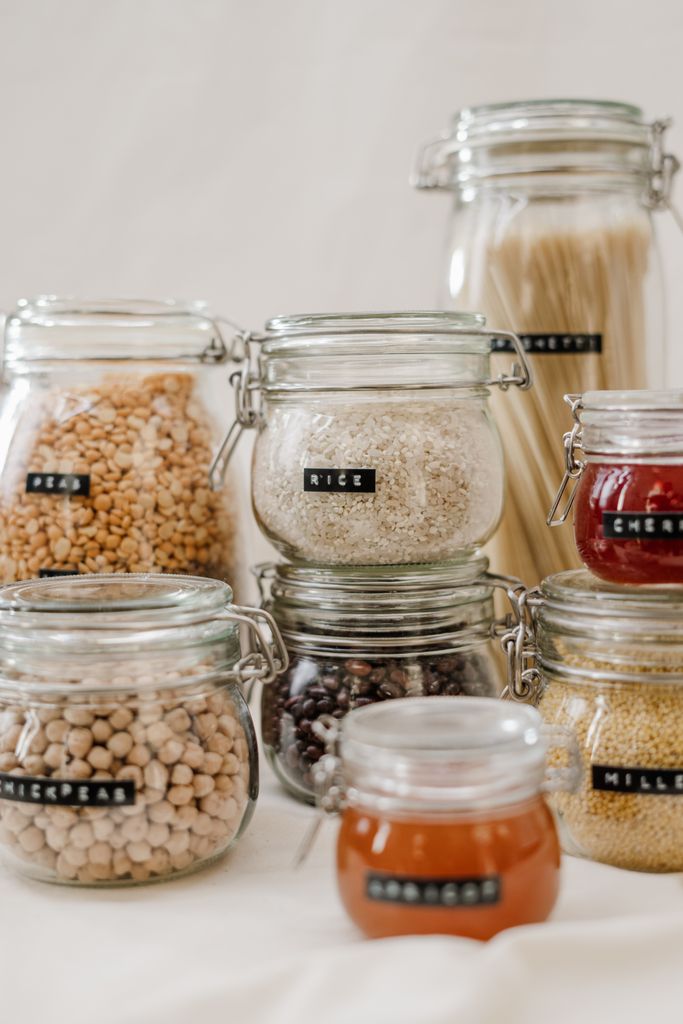 PFAS-free glass pantry jars neatly labeled with rice, chickpeas, pasta and preserves for non-toxic kitchen storage