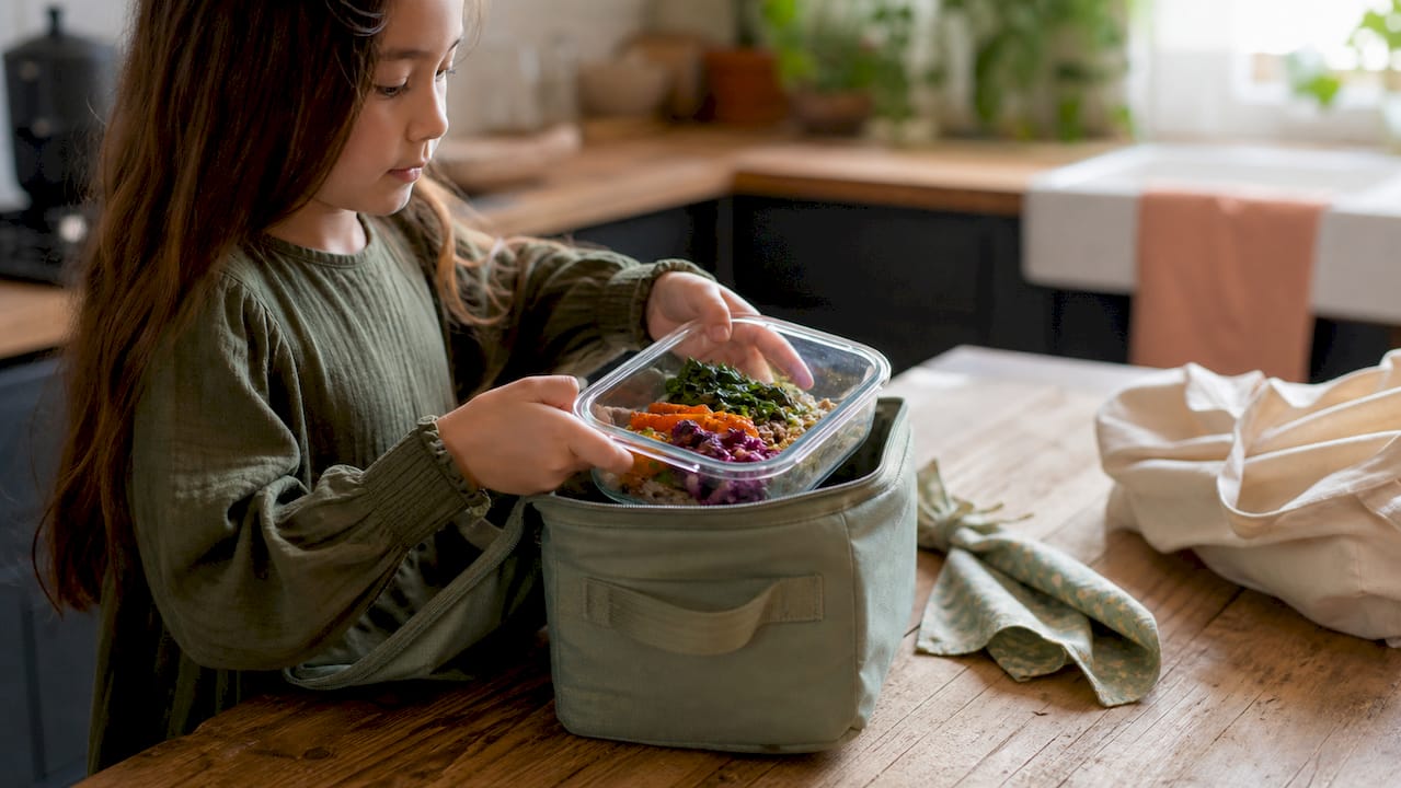Glass container being packed in insulated bag for a plastic free lunch