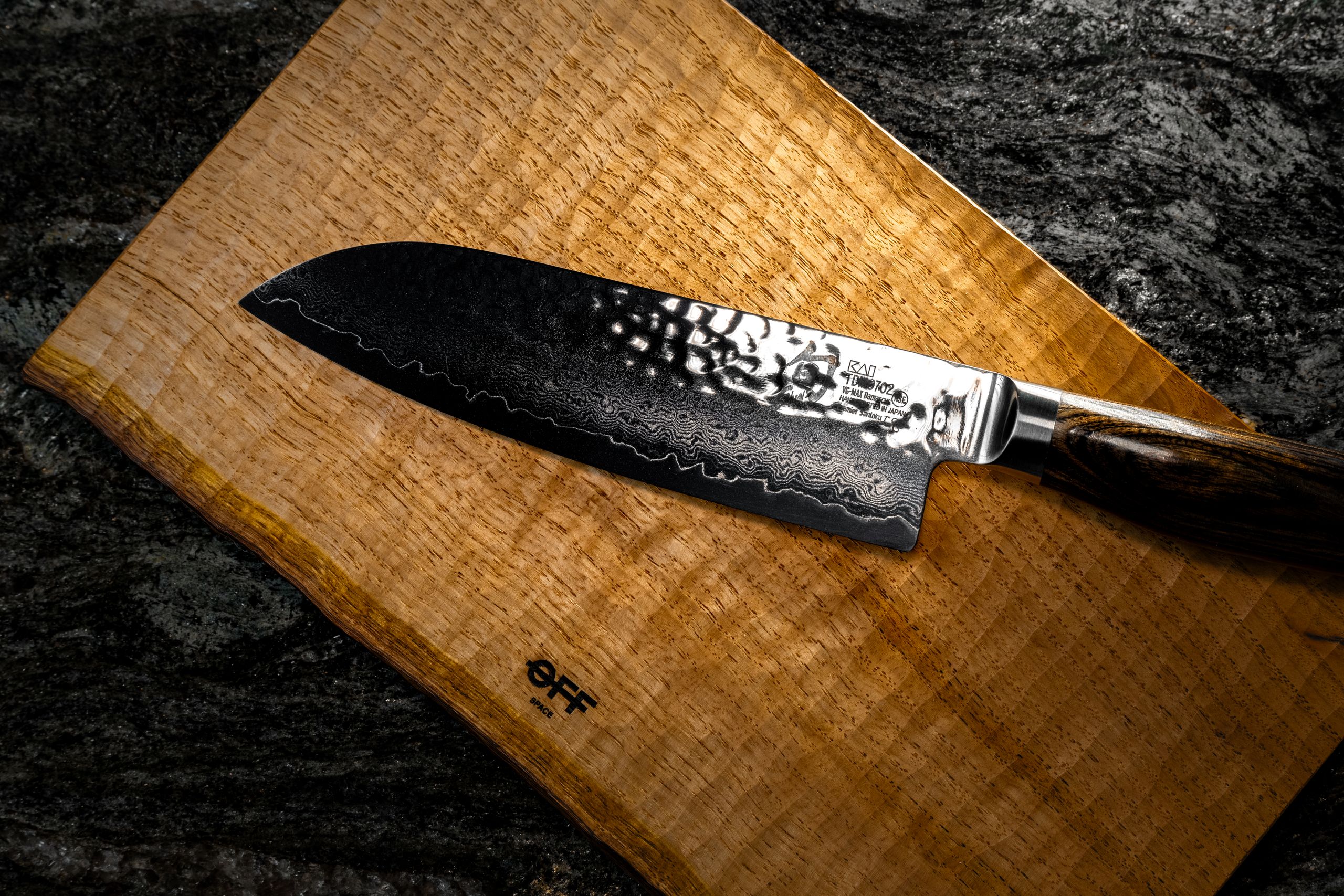 High-quality Santoku knife displayed on a textured wooden board, ideal for culinary settings.